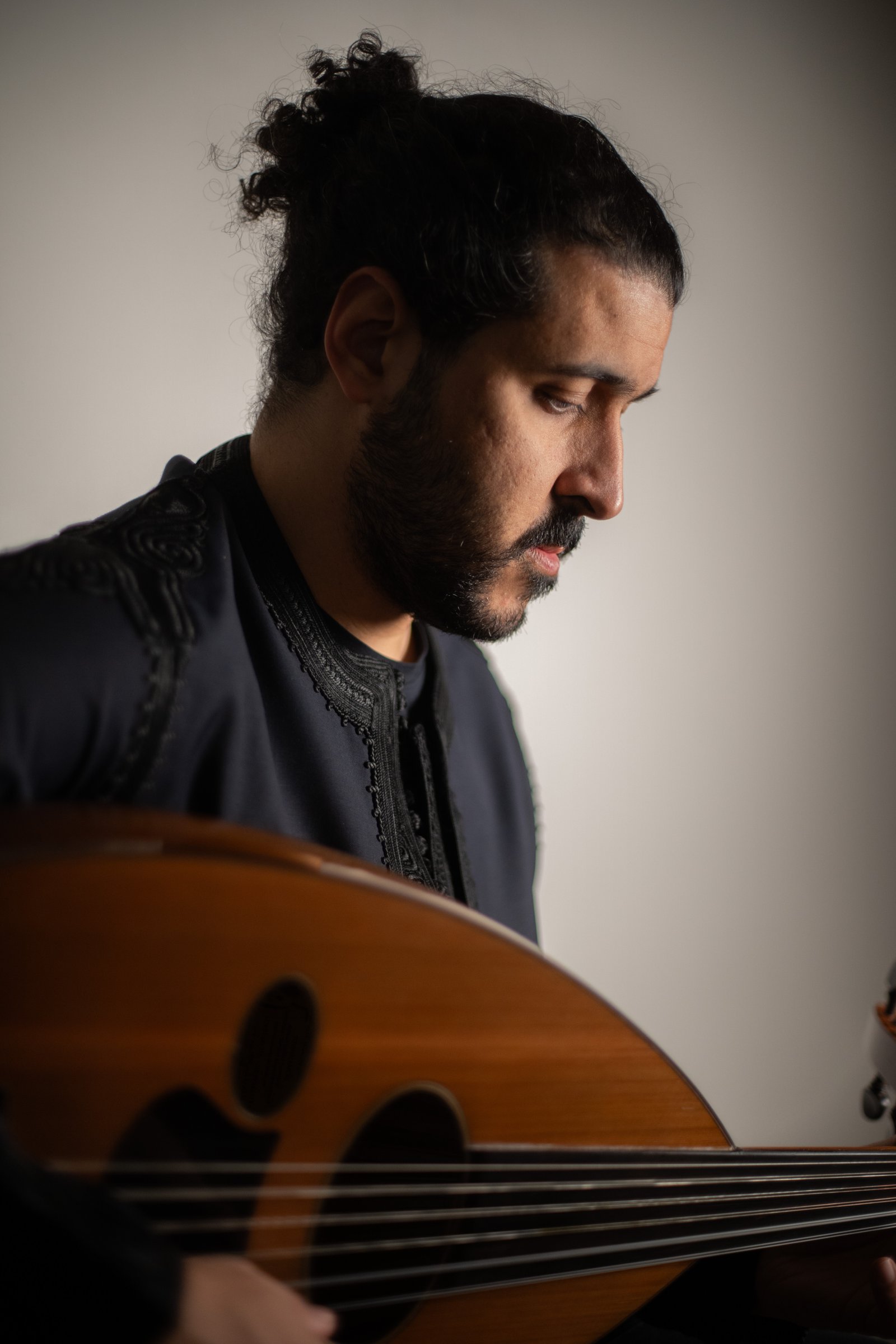 Portrait of Sufian Ararah holding an oud.